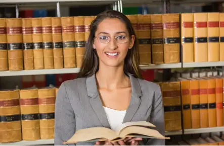 Law student in library holding a book